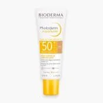 Tube blanc à capuchon jaune Bioderma Photoderm Aquafluide teintée dorée SPF50+