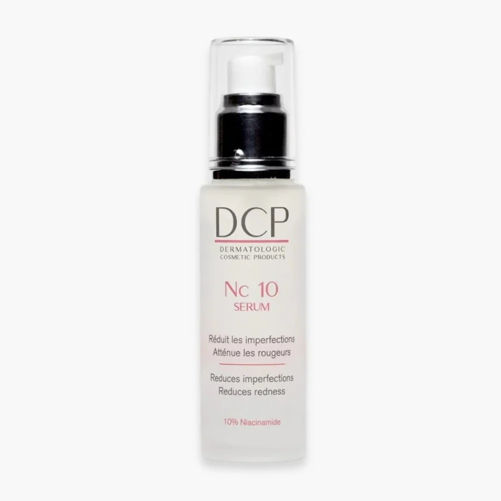 dcp-nc-10-serum-anti-imperfections-rougeurs-50ml.jpg Flacon pompe blanc sérum DCP Nc 10, texte rose sur verre dépoli