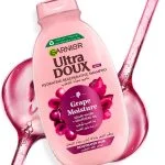 Flacon rose incliné Garnier Ultra Doux Grape Moisture avec coulée de jus de raisin