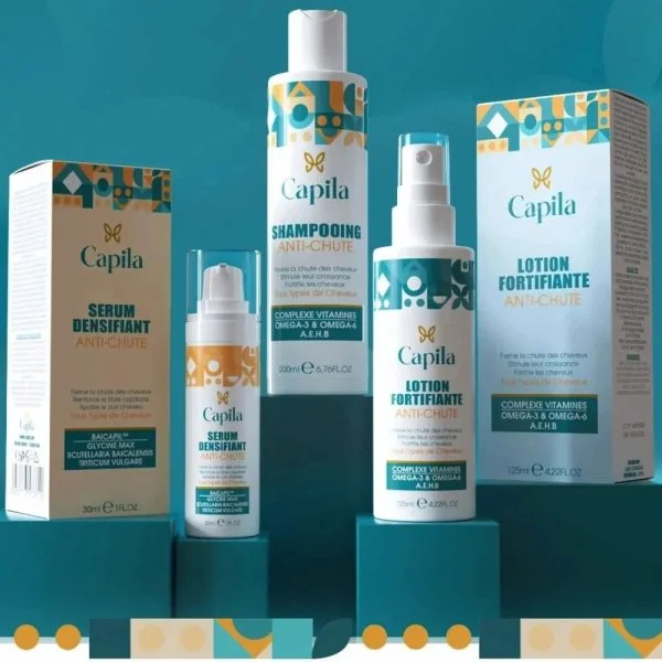Shampooing, lotion et sérum anti-chute Capila avec leurs étuis sur fond bleu canard